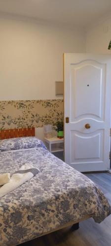 sypialnia z łóżkiem i białymi drzwiami w obiekcie El Colmenar Hospedaje w Madrycie