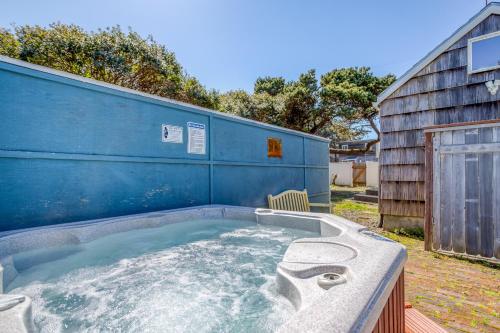 a jacuzzi tub in a yard next to a building at Surf Shack in Lincoln City