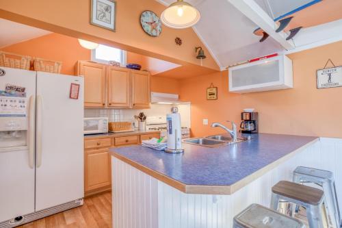 a kitchen with a white refrigerator freezer next to a counter at Surf Shack in Lincoln City