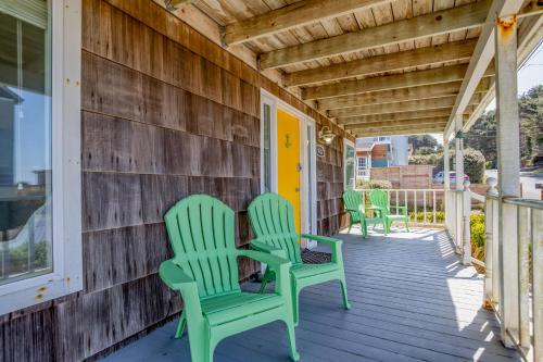 two green chairs sitting on the porch of a house at Surf Shack in Lincoln City