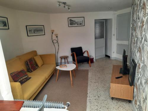 p'tite maison entre mer et campagne في Wimille: غرفة معيشة مع أريكة وطاولة