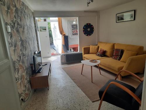 sala de estar con sofá y mesa en p'tite maison entre mer et campagne en Wimille