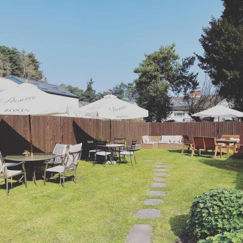 a patio area with chairs, tables and umbrellas at The Castle Inn in Usk