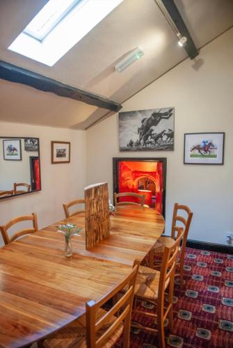 een eetkamer met een houten tafel en een open haard bij The Castle Inn in Usk