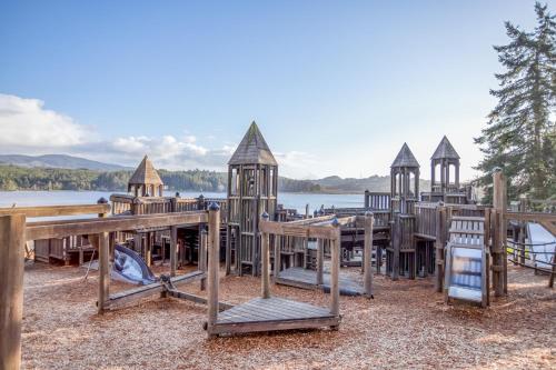 a group of wooden play structures next to a lake at Laurel Haven - Meredith Lodging in Otis