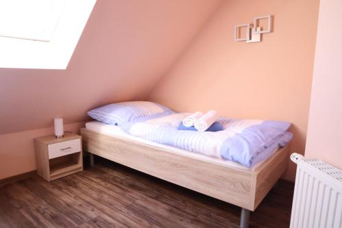 a small bedroom with a bed in a attic at Haus Ausreißer - Ausreißer in Bensersiel