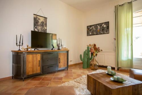 a living room with a flat screen tv on a wooden cabinet at Mas l aigo claro in Mouriès