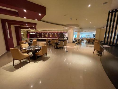 a restaurant with tables and chairs and a bar at Private Suites Al Hamra Palace at golf & sea resort in Ras al Khaimah