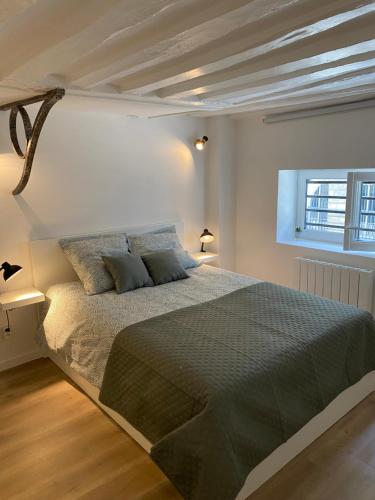 une chambre avec un grand lit dans une pièce blanche dans l'établissement Le Palm ✧ Duplex centre historique Rouen, à Rouen