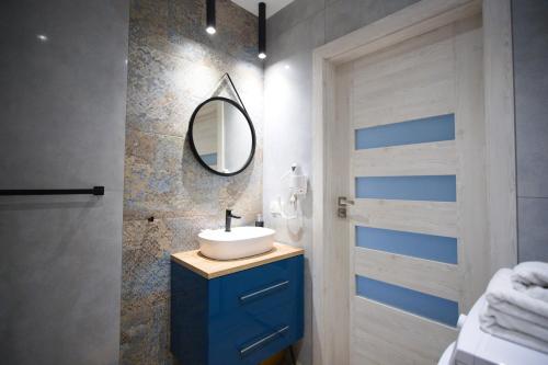 ein Badezimmer mit einem blauen Waschbecken und einem Spiegel in der Unterkunft Morska fala, Jantar in Jantar