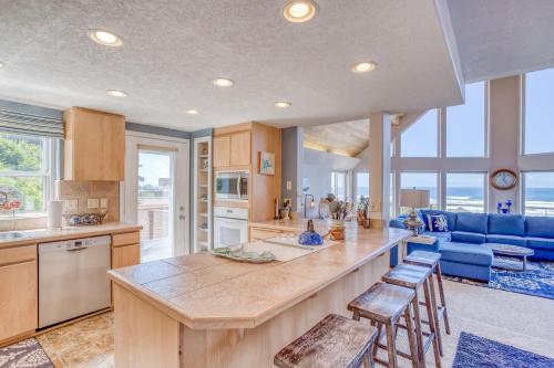a large kitchen with a large island with stools at Neptune Lookout in Lincoln City