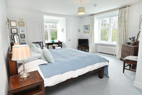a bedroom with a bed and a lamp and windows at Willowvale in Nairn