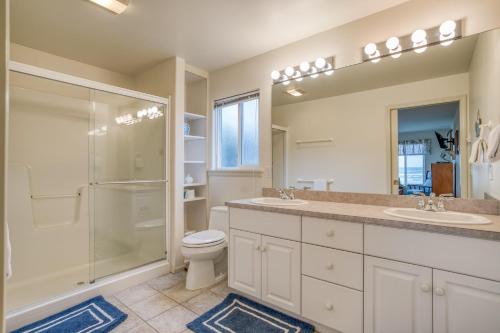 un bagno con due lavandini, una doccia e un WC di Payn House a Yachats