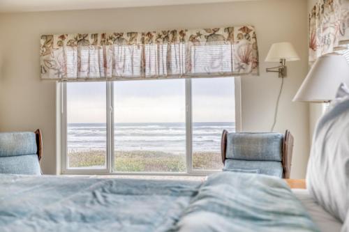 una camera da letto con finestra con vista sull'oceano di Payn House a Yachats