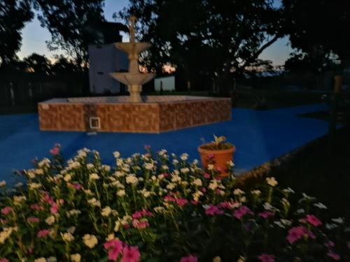 a fountain in the middle of a garden with flowers at Hotel campestre la Maria in Villavicencio