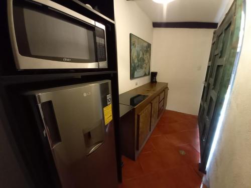 a kitchen with a microwave and a television in a room at Casa del Manchén in Antigua Guatemala