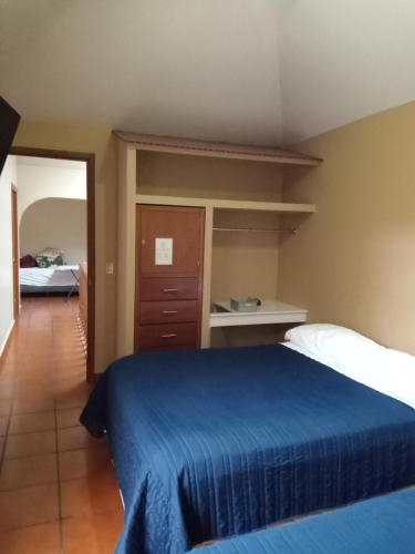 1 dormitorio con 1 cama con colcha azul en ROMA NORTE - POLANCO 4 kilometros Ciudad de Mexico, en Ciudad de México