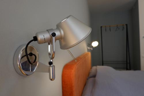 a lamp attached to a wall next to a bed at MUROS - City Modern Living in Trento in Trento