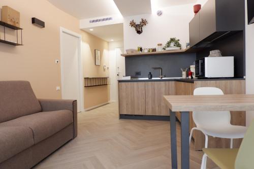 a kitchen and living room with a couch and a table at MUROS - City Modern Living in Trento in Trento