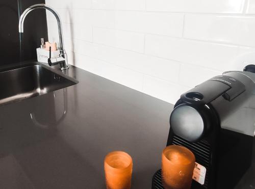 a kitchen counter with a coffee maker and two candles at Debaixo das Estrelas in Aveiro