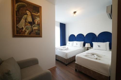 a hotel room with two beds and a painting on the wall at Hotel Vera in Istanbul