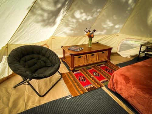a bedroom with a tent with a chair and a table at Glamping in the Redwoods in Garberville