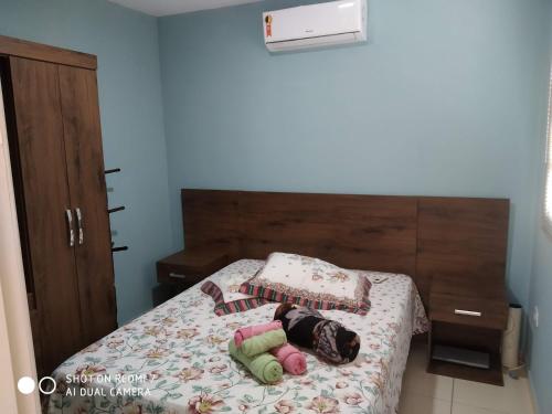 a bedroom with a bed with dolls laying on it at Aconchego in Maragogi