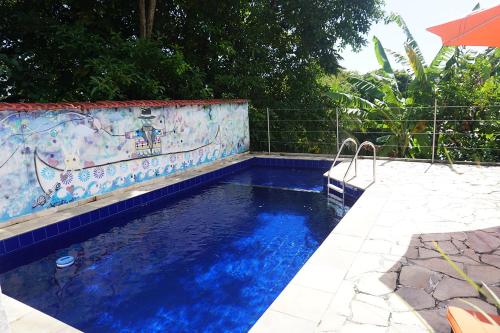 a swimming pool with blue water in front of a fence at casaJOMO Art & Food B&B in Rio de Janeiro