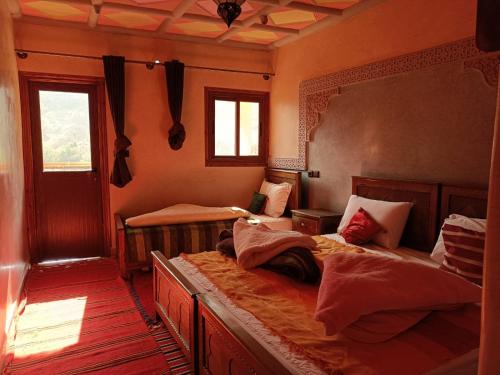 a bedroom with two beds and a mirror at Riad Atlas Sultana in Imlil