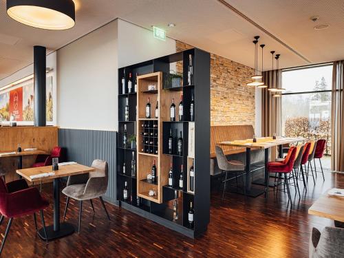a restaurant with tables and chairs and wine racks at Schlosshotel Hellenstein in Heidenheim