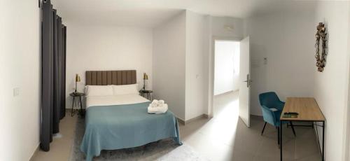 a bedroom with a bed and a table and a chair at Villamarta Boutique Rooms in Jerez de la Frontera