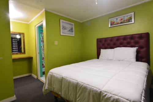 ein Schlafzimmer mit einem großen Bett mit grünen Wänden in der Unterkunft Royal Suites VR - New Kingston, Family Suite in Kingston