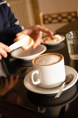 a person sitting at a table with a cup of coffee at Hotel Provincia in Trelew