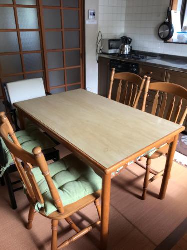 un tavolo e sedie in legno in cucina di 民泊　二見のおうち a Hutami