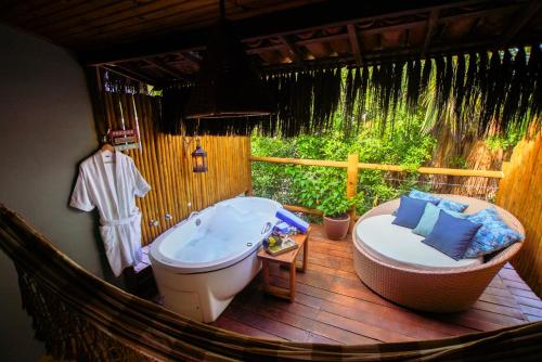 Xamã Senses - Hotel Pousada في بيبا: حمام مع حوض استحمام وحوض استحمام