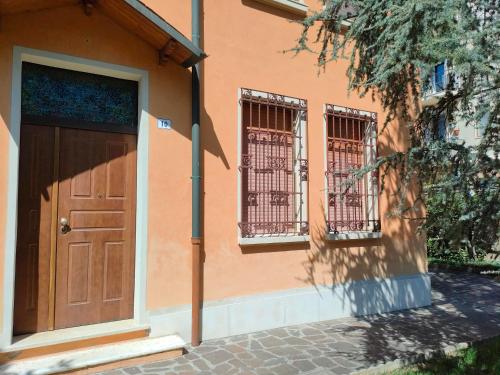 um edifício com uma porta castanha e duas janelas em Casa Timoteo em Mantova