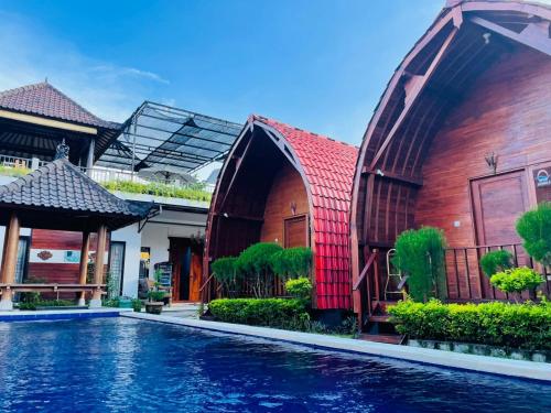 uma casa com piscina em frente a um edifício em Bemo Villas & Pool em Karangasem
