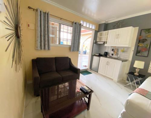 a living room with a chair and a kitchen at Little Norway Guesthouse - Mactan Cebu International Airport in Mactan
