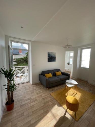 un salon avec un canapé et une table dans l'établissement Appartement rénové dans villa d'exception face à la mer, à Saint-Michel-Chef-Chef