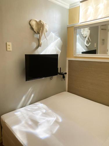 a bedroom with a bed and a television withanimal statues on the wall at Little Norway Guesthouse - Mactan Cebu International Airport in Mactan