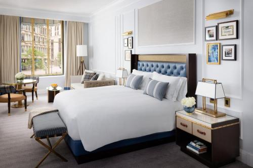 a bedroom with a large bed and a living room at The Langham, Boston in Boston
