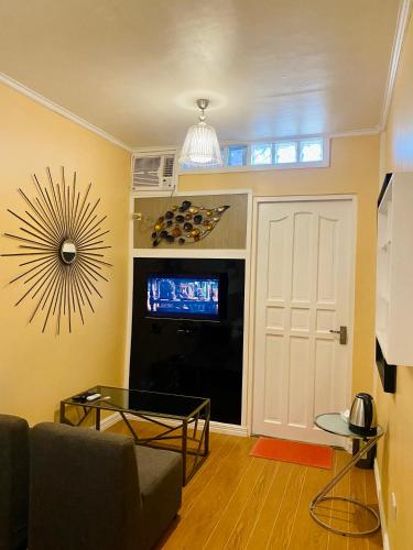 a living room with a couch and a tv and a door at Little Norway Guesthouse - Mactan Cebu International Airport in Mactan