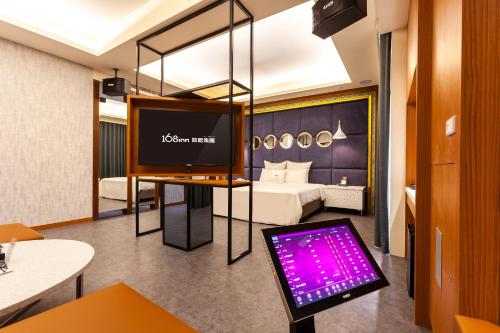 Habitación de hotel con cama y monitor de ordenador en Six Star Motel-Zhongli, en Zhongli