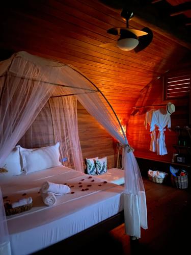 - une chambre avec un lit à baldaquin dans l'établissement Nature Moreré - Bangalôs com vista para o Mar, à Moreré