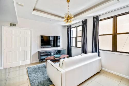 a living room with a white couch and a tv at Classic Modern with a splash of Glam 2BD Apt in Philadelphia