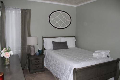 1 dormitorio con 1 cama y reloj en la pared en Williamsburgh Place, en Fayetteville