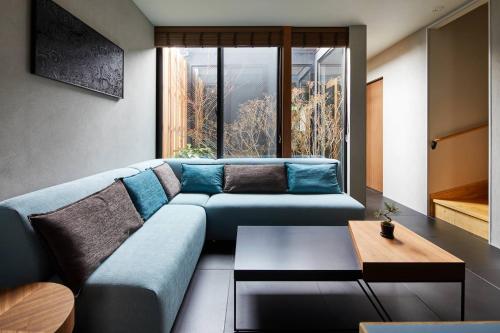 a living room with a blue couch and a table at HANARE KYOTO Hachijoguchi in Kyoto