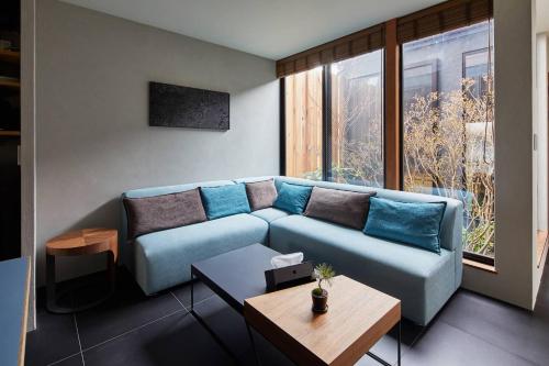 a living room with a blue couch and a table at HANARE KYOTO Hachijoguchi in Kyoto