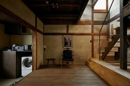 a laundry room with a chair and a washing machine at Umeyu no yado by YADORU KYOTO HANARE in Kyoto