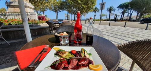 - une table avec une assiette de nourriture et une bouteille de vin dans l'établissement Studio with Fantastic sea view, à Banyuls-sur-Mer